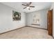 Bedroom with tile floors, fan, and window is staged with art at 12899 W Pasadena Ave, Litchfield Park, AZ 85340
