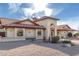 View of the house featuring stone landscaping, arched windows, and a red tiled roof at 12899 W Pasadena Ave, Litchfield Park, AZ 85340