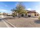 Inviting home featuring natural landscaping and a mature shade tree at 12899 W Pasadena Ave, Litchfield Park, AZ 85340