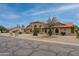 Charming single-story home boasting an arched entry, terra cotta roof, desert landscaping, and mature trees at 12899 W Pasadena Ave, Litchfield Park, AZ 85340
