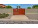 Private wooden gate leading to the backyard, desert landscaping at 12899 W Pasadena Ave, Litchfield Park, AZ 85340