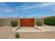 Private wooden gate leading to the backyard, desert landscaping at 12899 W Pasadena Ave, Litchfield Park, AZ 85340