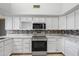 Updated kitchen with white cabinets, sleek countertops, and stainless steel appliances at 12899 W Pasadena Ave, Litchfield Park, AZ 85340