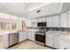 Kitchen with stainless steel appliances, white cabinets, and mosaic backsplash at 12899 W Pasadena Ave, Litchfield Park, AZ 85340