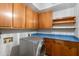 Practical laundry room with washer, ample cabinetry, and a durable blue countertop at 12899 W Pasadena Ave, Litchfield Park, AZ 85340