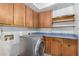 Functional laundry area with built-in cabinets, countertop and modern front load washer at 12899 W Pasadena Ave, Litchfield Park, AZ 85340