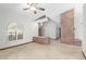 A bright, open living room with tile floors, large brick feature, and shuttered windows at 12899 W Pasadena Ave, Litchfield Park, AZ 85340