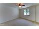 This bedroom features a neutral color palette, carpeted floors, a ceiling fan, and natural lighting at 1423 W Joan De Arc Ave, Phoenix, AZ 85029
