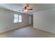 This bedroom features carpeted floors, a ceiling fan, a window, and natural lighting at 1423 W Joan De Arc Ave, Phoenix, AZ 85029