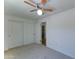 This bedroom includes a ceiling fan, carpeted floors, and a closet with sliding doors at 1423 W Joan De Arc Ave, Phoenix, AZ 85029