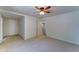This bedroom features carpeted floors, a ceiling fan, and an entry door at 1423 W Joan De Arc Ave, Phoenix, AZ 85029