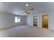 Spacious bedroom with carpeted floors, ceiling fan, and convenient access to an ensuite bathroom at 1423 W Joan De Arc Ave, Phoenix, AZ 85029