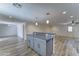 Bright and open kitchen with a gray island, pendant lighting, and wood-look tile flooring at 1423 W Joan De Arc Ave, Phoenix, AZ 85029