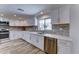 Stylish kitchen with white cabinetry, stainless steel appliances, and wood backsplash tiles at 1423 W Joan De Arc Ave, Phoenix, AZ 85029