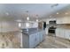 Updated kitchen featuring white cabinets, stainless steel appliances, and a gray kitchen island at 1423 W Joan De Arc Ave, Phoenix, AZ 85029