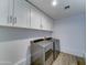 Laundry room featuring modern white cabinets and modern washer and dryer at 1423 W Joan De Arc Ave, Phoenix, AZ 85029