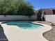 Backyard pool with white concrete deck, set against block wall and lush greenery at 1423 W Joan De Arc Ave, Phoenix, AZ 85029