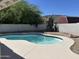 Backyard pool with white concrete deck, set against block wall and lush greenery at 1423 W Joan De Arc Ave, Phoenix, AZ 85029