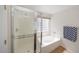 Clean bathroom with a shower, bathtub, checkered accents, and natural light at 14552 W Hearn Rd, Surprise, AZ 85379