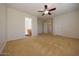 Spacious bedroom with neutral walls, ceiling fan, and access to a bathroom at 14552 W Hearn Rd, Surprise, AZ 85379