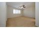 Spacious bedroom featuring neutral tones, a ceiling fan, and a large window at 14552 W Hearn Rd, Surprise, AZ 85379