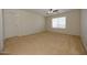 Spacious bedroom featuring neutral tones, a ceiling fan, and a large window at 14552 W Hearn Rd, Surprise, AZ 85379