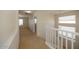 Bright hallway with carpet flooring, white banister, and neutral walls with natural light from windows at 14552 W Hearn Rd, Surprise, AZ 85379
