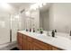 Bathroom featuring a double sink vanity with a large mirror and a glass-enclosed shower at 15134 N 138Th Ln, Surprise, AZ 85379
