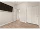 Bright bedroom featuring wood floors, closet with sliding doors, and an open doorway to the rest of the home at 15134 N 138Th Ln, Surprise, AZ 85379