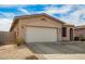Single-story home with desert landscaping, two-car garage, and covered arched entry at 15134 N 138Th Ln, Surprise, AZ 85379