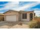 Charming tan single-story home with desert landscaping, two-car garage and arched front entry at 15134 N 138Th Ln, Surprise, AZ 85379