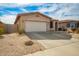 Single-story home with desert landscaping, attached two car garage, and covered arched entry at 15134 N 138Th Ln, Surprise, AZ 85379