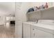 Convenient laundry room features a washer and dryer with storage shelves and easy access to the main living area at 15134 N 138Th Ln, Surprise, AZ 85379
