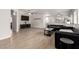 Open-concept living room with gray sofas, stylish wood floors, and ample natural light at 15134 N 138Th Ln, Surprise, AZ 85379