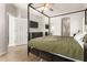 This main bedroom boasts a four-poster bed frame, ceiling fan, and ensuite bathroom and closet at 15134 N 138Th Ln, Surprise, AZ 85379
