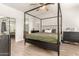 This main bedroom boasts a four-poster bed frame, ceiling fan, and ensuite bathroom and closet at 15134 N 138Th Ln, Surprise, AZ 85379