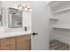 Bathroom view to include a light wood vanity, modern light fixture, and a closet at 1633 E Beverly Ln, Phoenix, AZ 85022