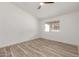 Simple bedroom design with a ceiling fan, wood-look floors, and one large window at 1633 E Beverly Ln, Phoenix, AZ 85022