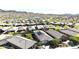 Expansive aerial view of a residential neighborhood featuring beautiful homes and picturesque desert landscape, enhanced by yellow flowering trees at 16521 W Magdalena Ln, Goodyear, AZ 85338