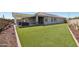 Expansive backyard with lush artificial turf and a covered patio area at 16521 W Magdalena Ln, Goodyear, AZ 85338