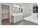 This bathroom features double sinks, a large mirror, and stylish lighting fixtures at 16521 W Magdalena Ln, Goodyear, AZ 85338