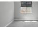 This bedroom has gray walls, carpet, a window with blinds and an outlet near the floor at 16521 W Magdalena Ln, Goodyear, AZ 85338