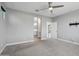 A bedroom features neutral walls, ceiling fan, and doorways to the bathroom and hallway at 16521 W Magdalena Ln, Goodyear, AZ 85338
