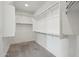 This walk in closet has white walls, carpet, and shelving and racks for hanging clothes at 16521 W Magdalena Ln, Goodyear, AZ 85338