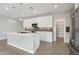 A modern kitchen features an island with white quartz countertops and cabinets and mosaic tile backsplash at 16521 W Magdalena Ln, Goodyear, AZ 85338