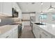 A sleek kitchen features white countertops and cabinets, stainless steel appliances, and mosaic tile backsplash at 16521 W Magdalena Ln, Goodyear, AZ 85338