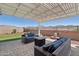 Inviting covered patio with stylish wicker furniture, a fire pit, and manicured landscaping at 16521 W Magdalena Ln, Goodyear, AZ 85338