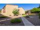 Community courtyard with green bushes, trees, walking path, and multiple buildings at 1730 W Emelita Ave # 2027, Mesa, AZ 85202