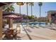 Relaxing community pool with lounge chairs, umbrellas, and palm trees at 1730 W Emelita Ave # 2027, Mesa, AZ 85202