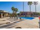 Community pool with lounge chairs and umbrellas surrounded by palm trees at 1730 W Emelita Ave # 2027, Mesa, AZ 85202